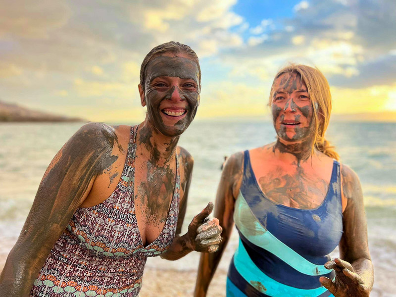 two girls covered in mud dead sea