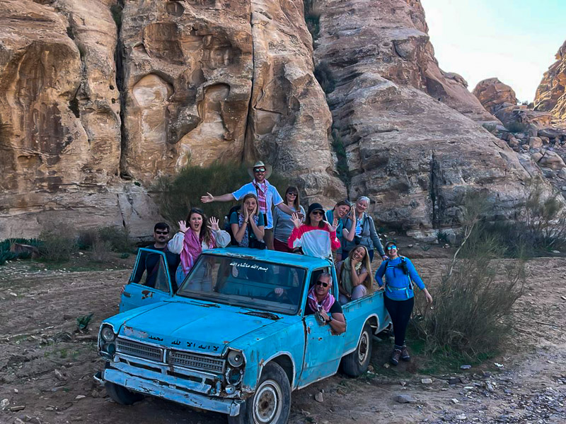 group of people standing on a rusted pick up