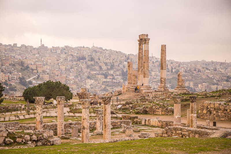 crumbling columns of Temple of Hercules Citadel with the hills of amman covered in buildings in the background