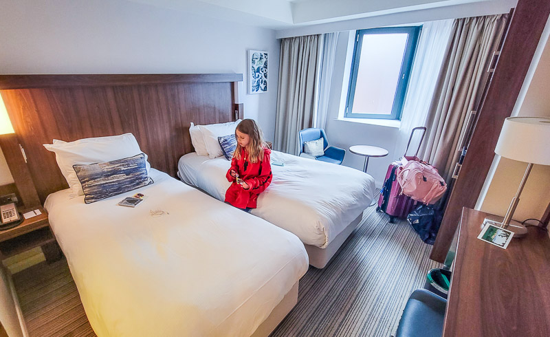 girl sitting on a hotel bed