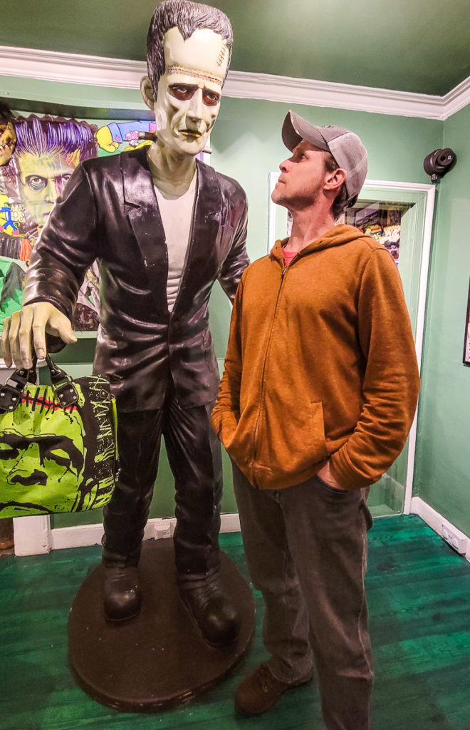 man standing in front of a model of a monster