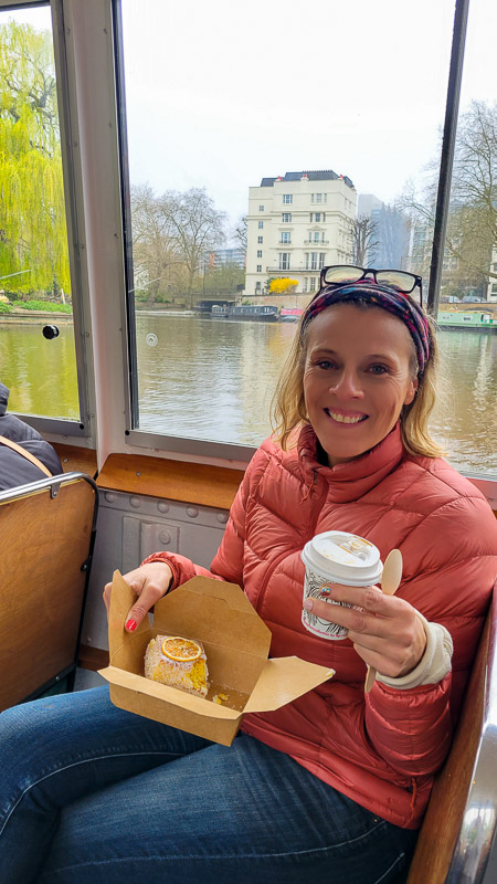 woman sitting on canal boat with coffee and lamington