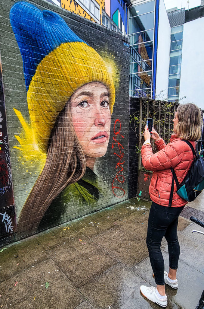 woman taking a photo of a mural