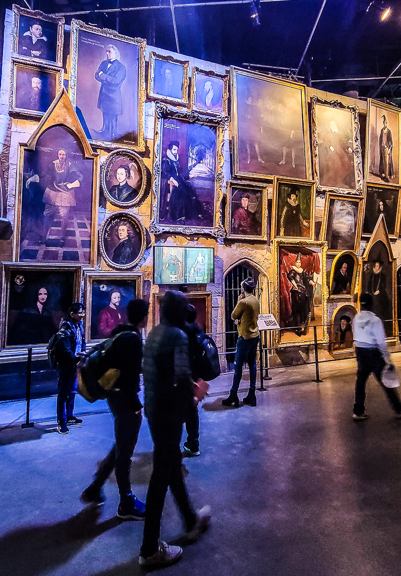 people standing in front of a wall of paintings