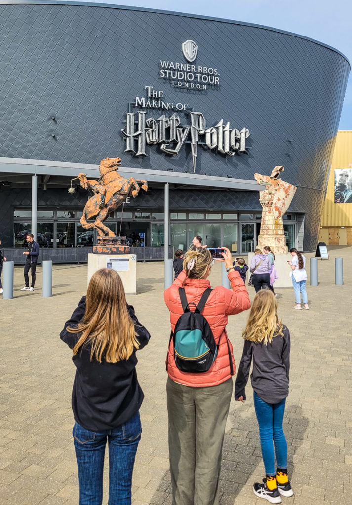 people standing in front of a building with a harry potter sign