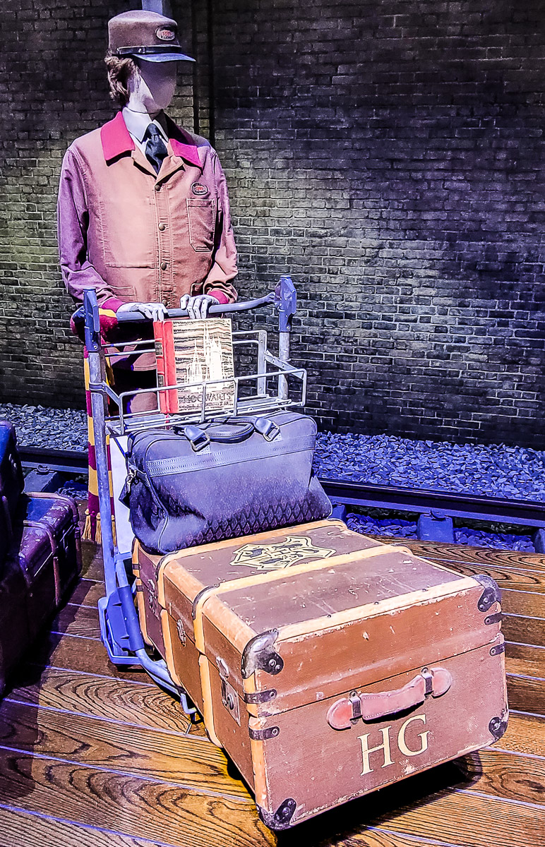 movie prop of a mannequin pushing a cart of luggage