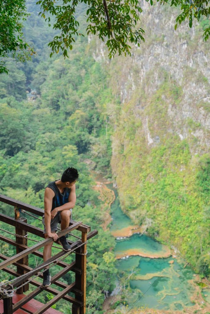 Man enjoying the views over green pools, canyon and jungle of -Semuc Champey Guatemala