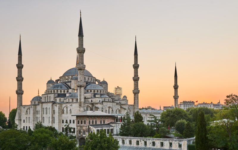 the blue mosque at sunset with a beautiful orange sky