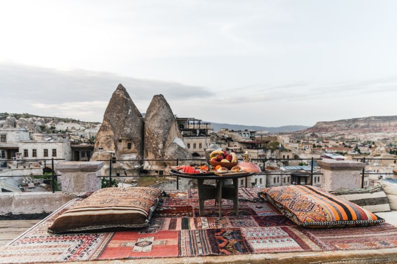 Small table and cushions on a Turkish carpet overlooking the village of Goreme, Cappadocia