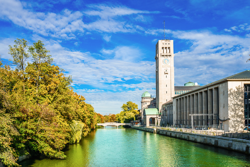 museum building with towers and green domes on the Isar River during Fall