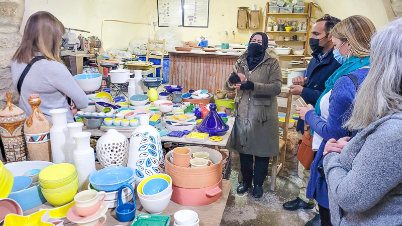 group of people standing in a ceramic shop