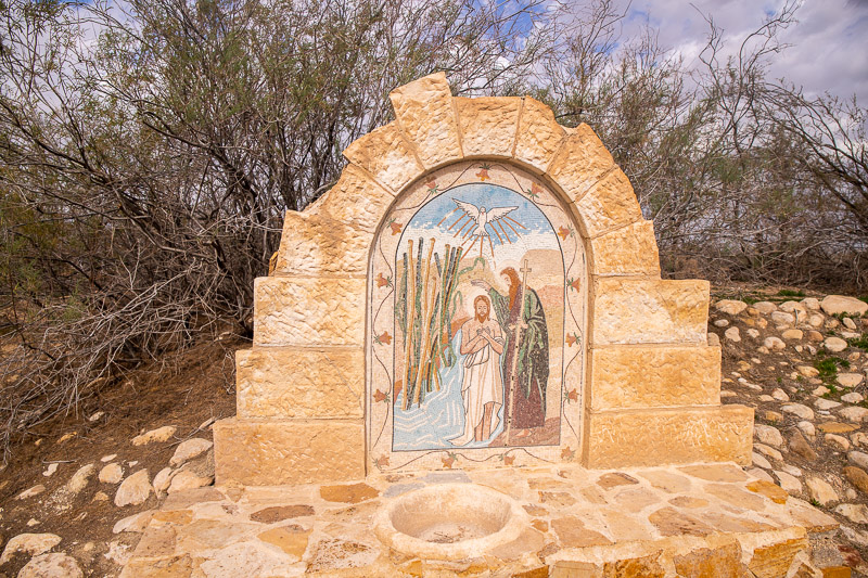 brick sculpture with mural of john baptizing jesus