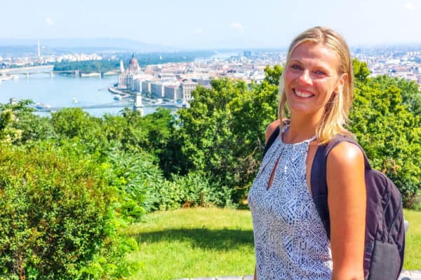 woman standing on grassy hill with budapest views in background