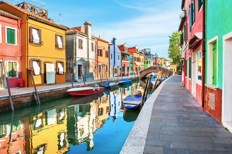 Colorful houses with reflections on the canal in Burano island, Venice, Italy