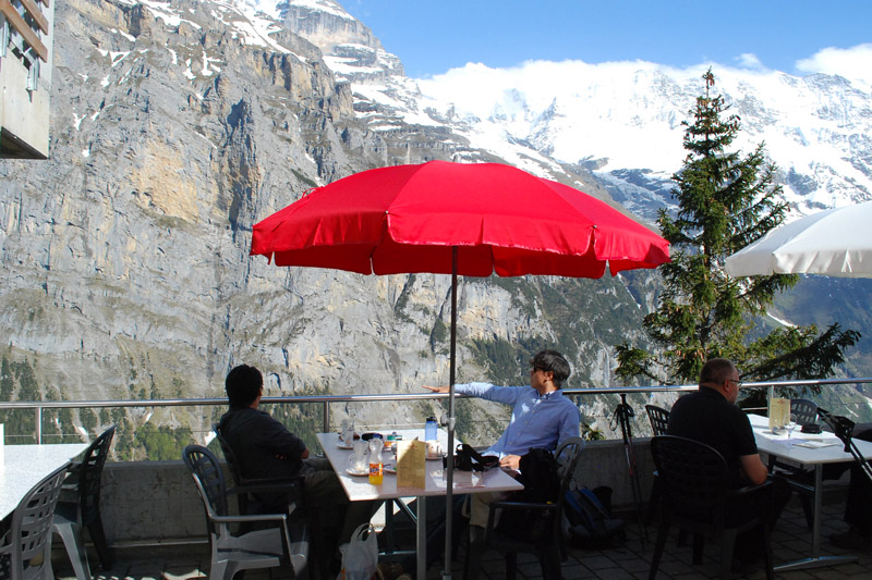 People sitting on terrace with views of snow capped peaks