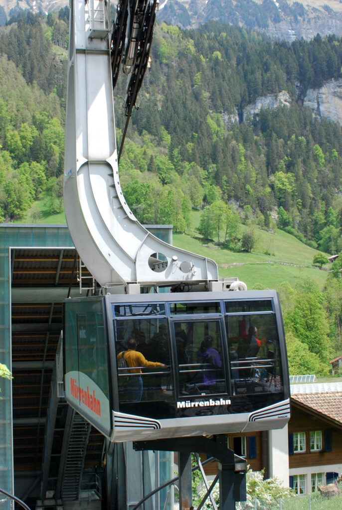 cable car ready to go up steep green mountain