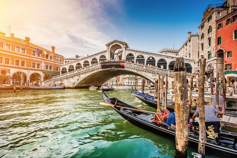 Panoramic view of famous Canal Grande with famous Rialto Bridge at sunset in Venice, Italy