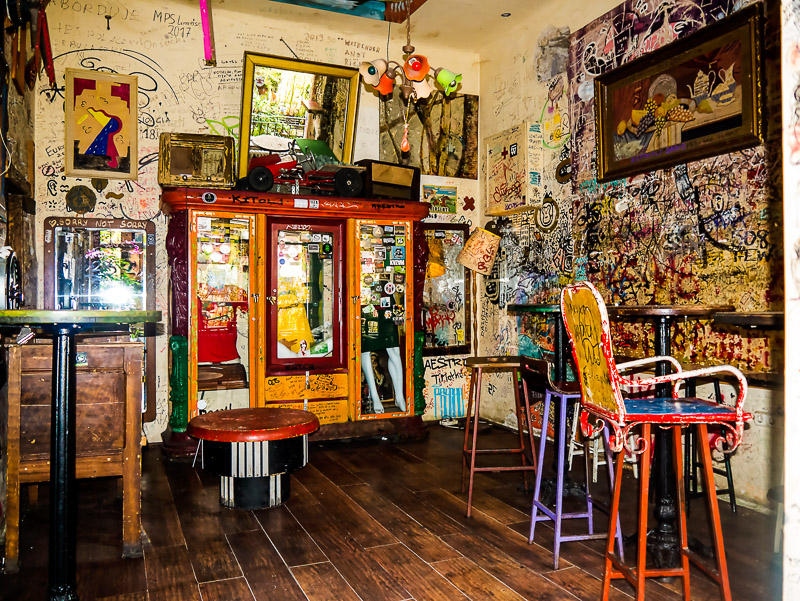 Insides of a ruin bar with grafitti on the walls and chairs