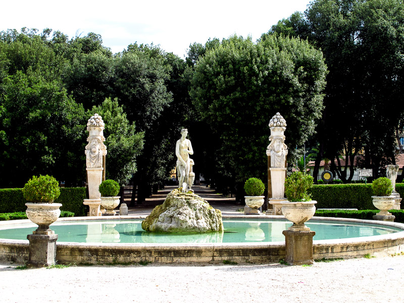 Water fountain with statues and trees in the Villa Borghese gardens