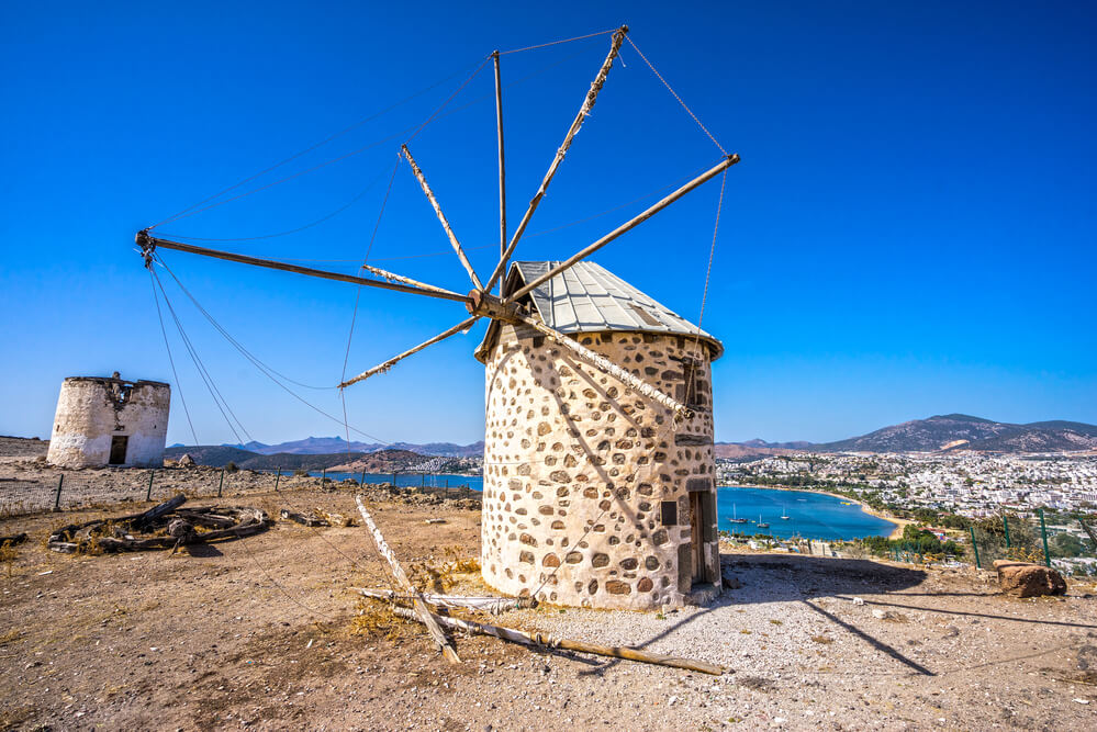 windmill on cliff with views of beach in the background