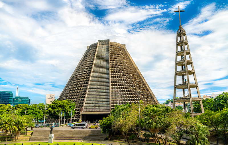 pyramid shaped building with circular tower and cross ont op  of Metropolitan Cathedral of Saint Sebastian in Rio de Janeiro