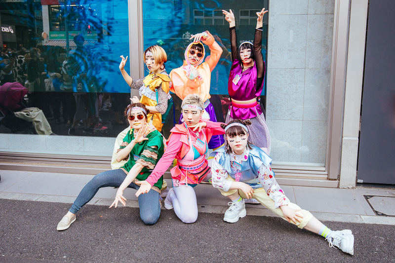 women posing in bright colored cosplay outfits