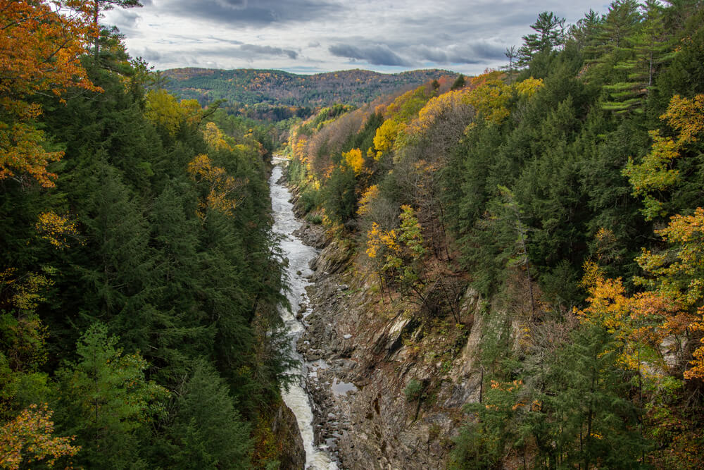 river running through quechee gorge vermont wiht fall foliage