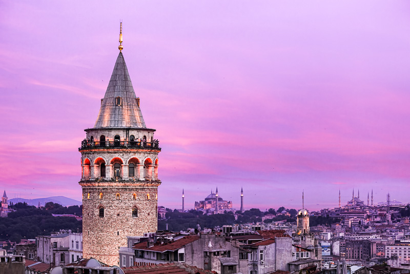 galata pointed tower at sunset with views of mosques in background