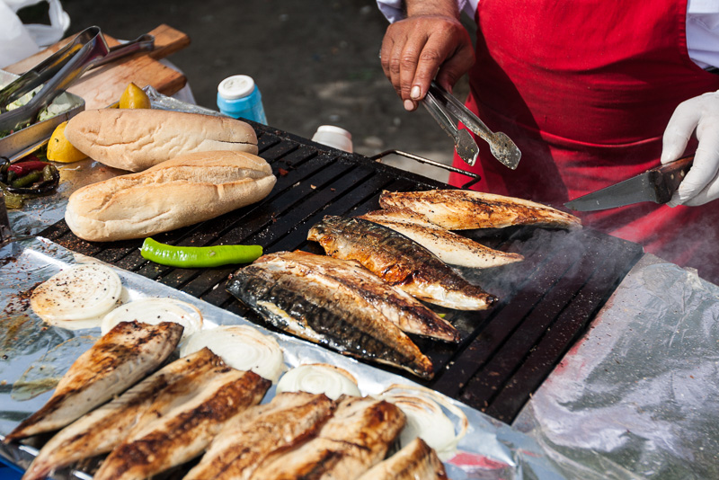 man grilling fish on street bbq istanbul