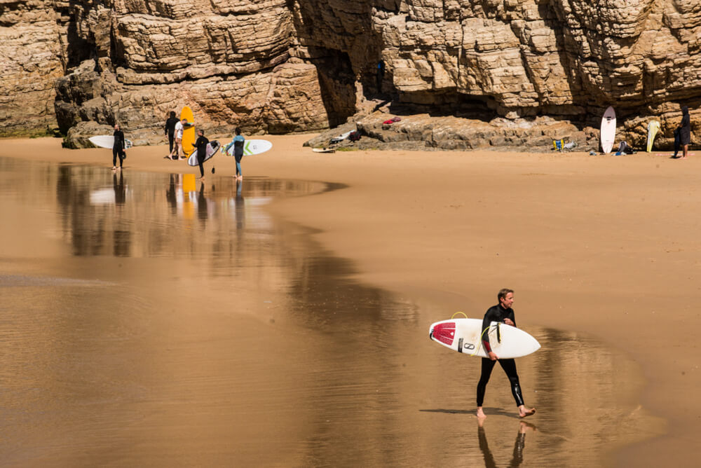 surfers walking on beach with their boards
