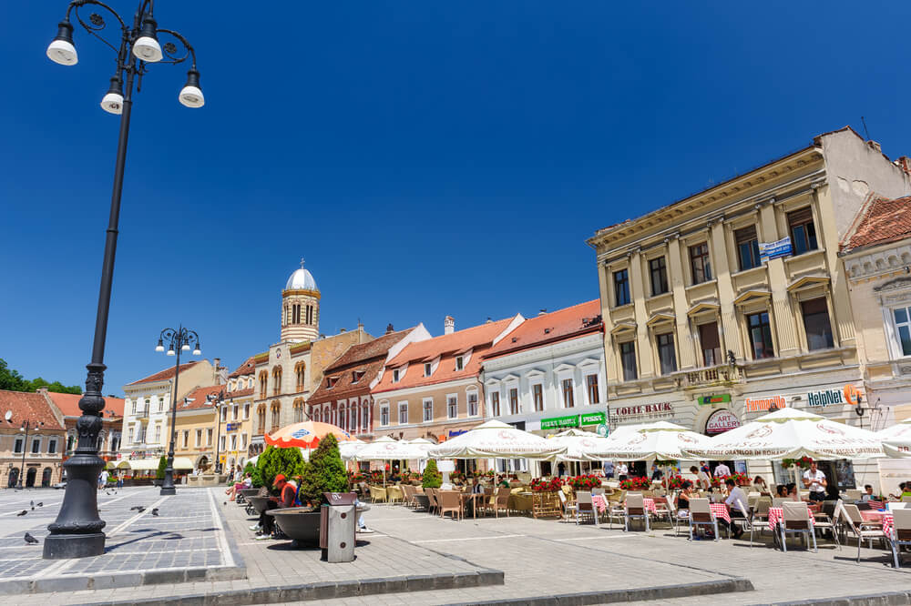 city square with restaurants and colorful buildings Brasov