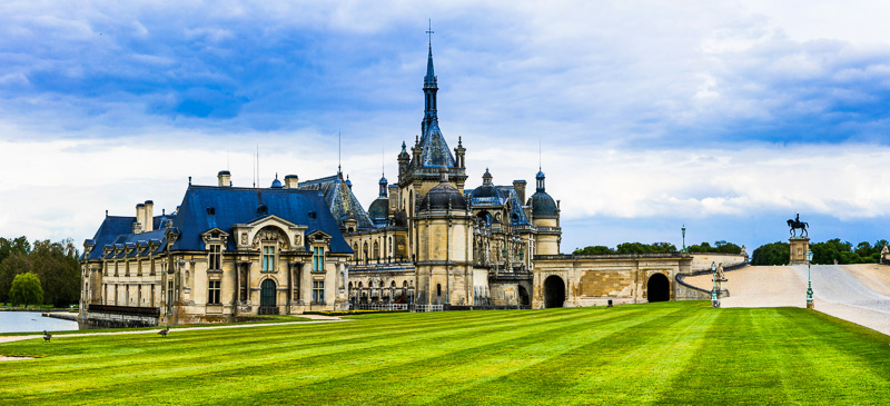 grand Chateau de Chantilly connected  greenish  lawn