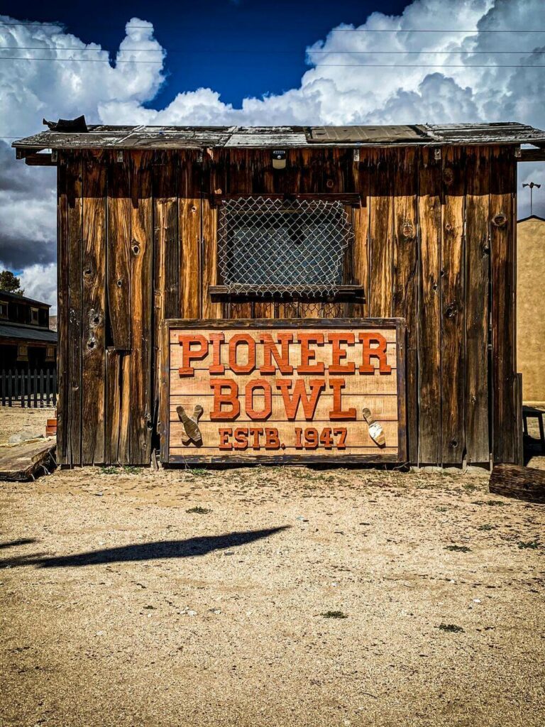 old wooden building with sign that says Pioneer Bowl