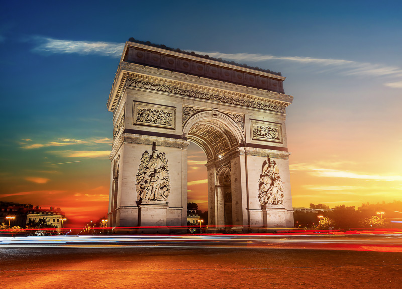 Arch of Triomphe in Paris at sunrise with red and white car light trails from long exposure