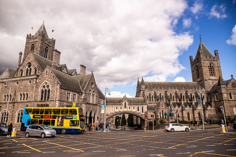 Bus and car passing by a cathedral in Dublin