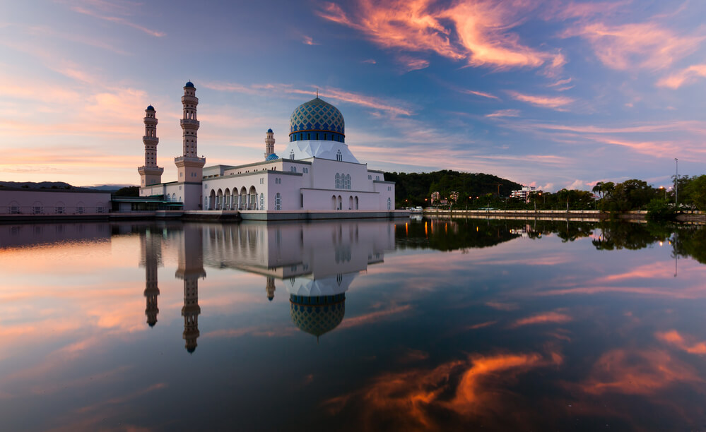 white Masjid Bandaraya Kota Kinabalu on river atg sunset