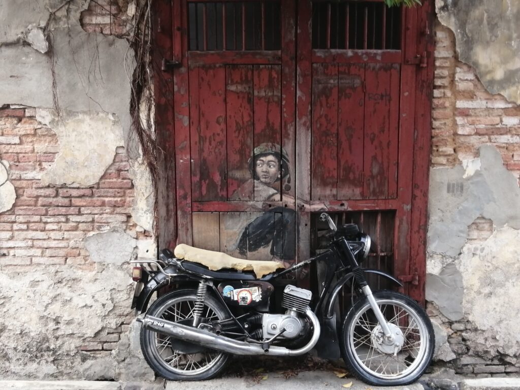 motobrike in front of brick wall and red door