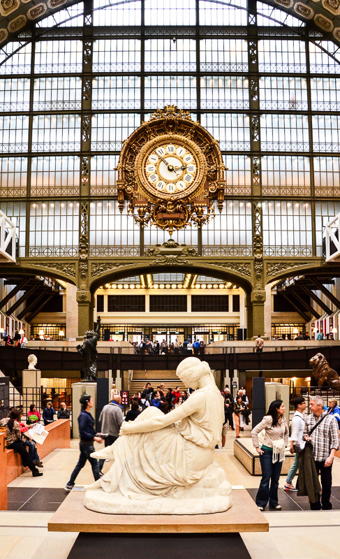  Visitors looking astatine  achromatic  sculpture of pistillate   with timepiece  successful  the inheritance  connected  solid  domed ceiling and walls successful  the Musee d'Orsay
