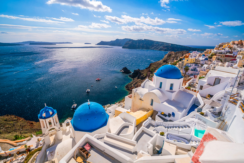 white buildings and blue roofs on cliff edge of santorini