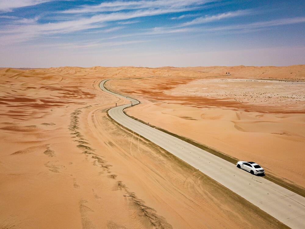 car driving through the orange desert of the Empty Quarter