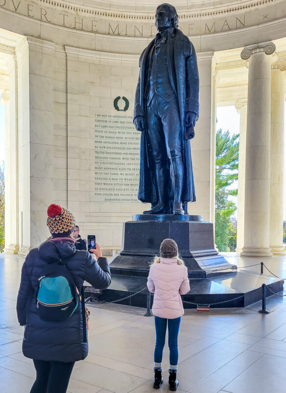 Mom and daughter taking a photo of a monument