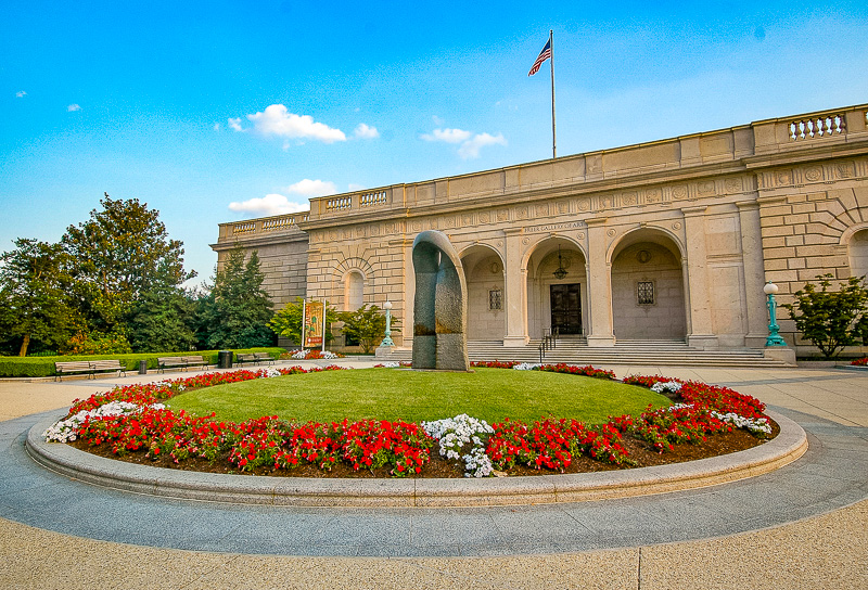 exterior of the freer gallery of asian art with circle of red flowers in front
