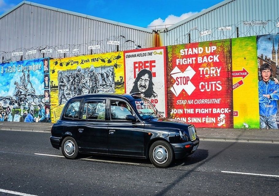 Black taxi in front of a wall of murals in Belfast, Ireland