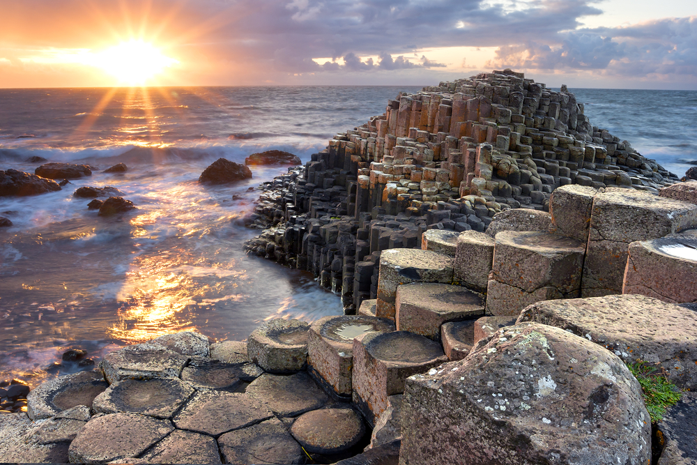 Hexagonal shaped rocks by the ocean with the sun setting