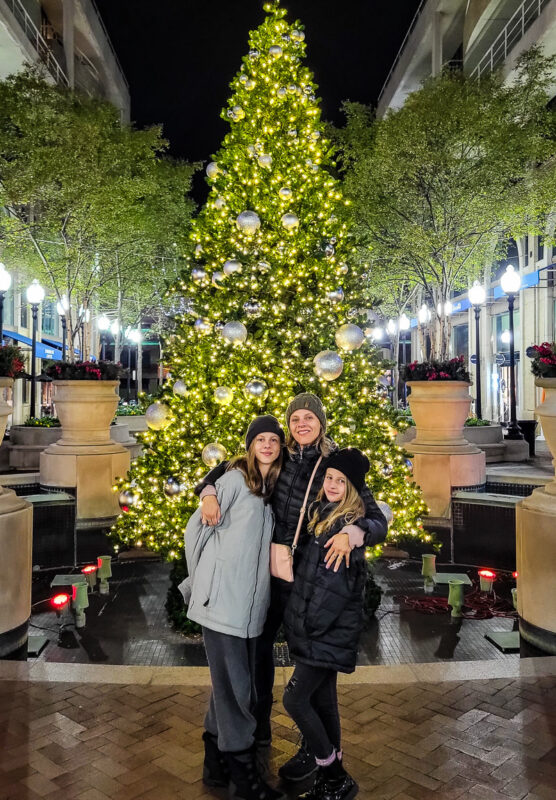 Mom and two daughters getting photo in front of a Christmas tree
