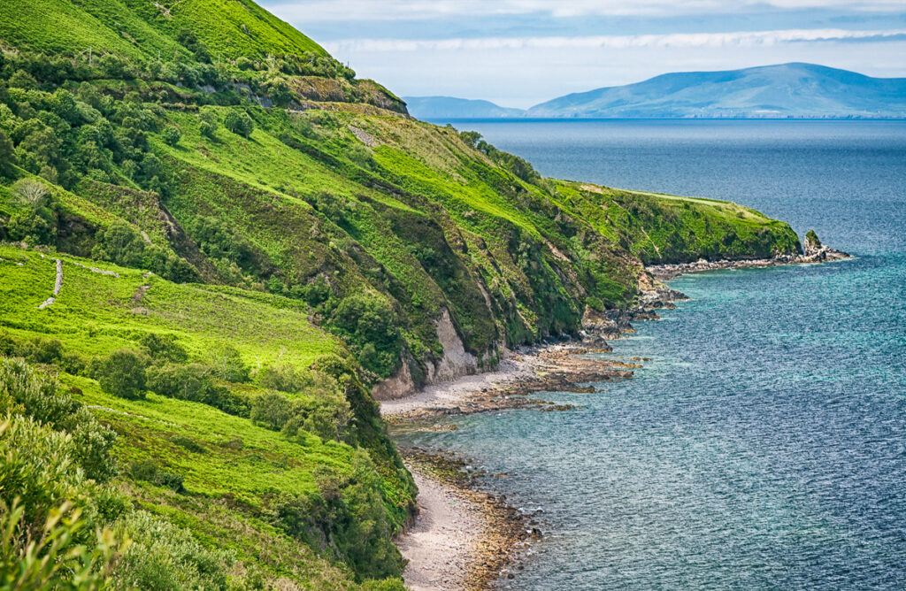 Coastal scenery of lush green mountains and blue ocean on the west coast of Ireland