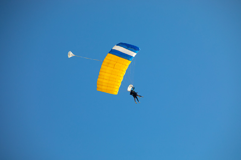 Skydivers in the air, pov directly above from beach