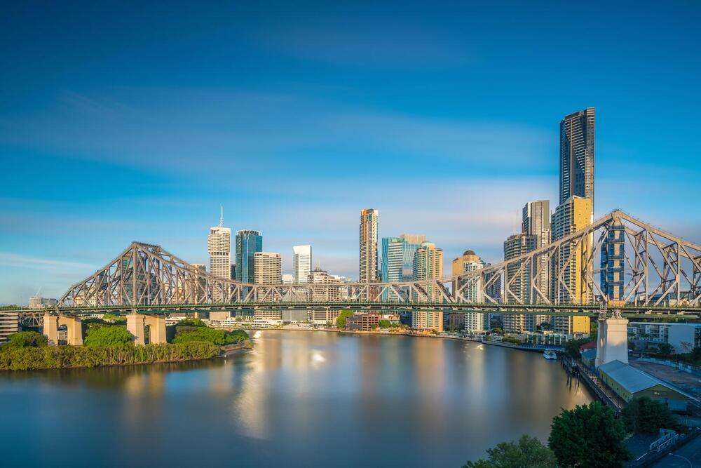 bridge crossing river wtih Brisbane skyline behind it