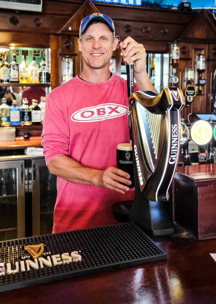 Man pulling a beer behind a bar