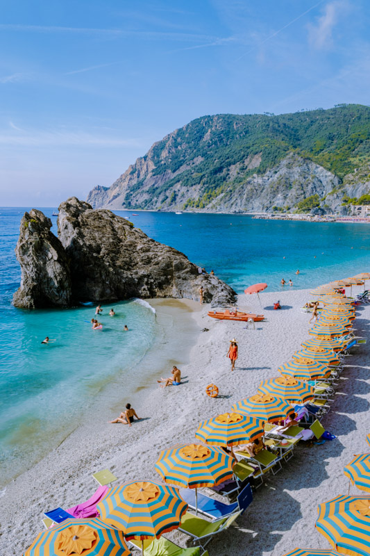 Chairs and umbrellas fill the spiaggia di fegina beach , the wide sandy beach village of Monterosso Italy, part of the Cinque Terre Italy